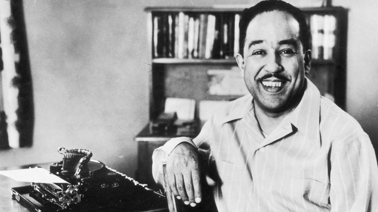 Langston Hughes writing on a typewriter         (Biography.com (A photograper))